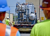 Employees position the carbon treatment system on the ground. Employees position the carbon treatment system on the ground.
