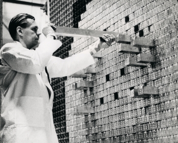 In 1958, Argonne National Laboratory began the construction of several zero-power reactors (ZPRs), which are nuclear fission reactors that don't actually generate any power. Scientists developed ZPRs to assess the performance of various reactor core configurations before actually building a full nuclear reactor. A series of ZPRs were built leading up to the construction of the Experimental Breeder Reactor-II, a sodium-cooled fast reactor power plant.
In this 1970 photo, an Argonne scientist is loading the matrices of the ZPR-VI reactor prior to its first operation using plutonium fuel. | Photo courtesy of the Department of Energy. In 1958, Argonne National Laboratory began the construction of several zero-power reactors (ZPRs), which are nuclear fission reactors that don't actually generate any power. Scientists developed ZPRs to assess the performance of various reactor core configurations before actually building a full nuclear reactor. A series of ZPRs were built leading up to the construction of the Experimental Breeder Reactor-II, a sodium-cooled fast reactor power plant.
In this 1970 photo, an Argonne scientist is loading the matrices of the ZPR-VI reactor prior to its first operation using plutonium fuel. | Photo courtesy of the Department of Energy.