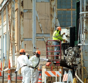 Workers drill holes for installation of electrodes as part of a heating system to help clean up contamination. Workers drill holes for installation of electrodes as part of a heating system to help clean up contamination.
