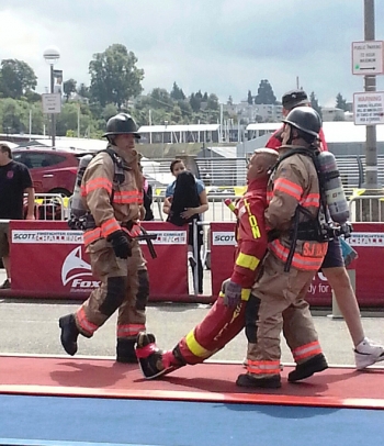 Hanford Fire Department Lt. Anthony Lovato, Jr. (left) urges his teammate, Capt. Sean Barajas, to carry the 175-pound life-sized dummy across the finish line at the Scott Firefighter Combat Challenge in Everett, Wash. Hanford Fire Department Lt. Anthony Lovato, Jr. (left) urges his teammate, Capt. Sean Barajas, to carry the 175-pound life-sized dummy across the finish line at the Scott Firefighter Combat Challenge in Everett, Wash.
