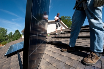 Brian Webster (left) and Mario Richard install photovoltaic modules on an Englewood, Colorado, home. | Photo by Dennis Schroeder, NREL. Brian Webster (left) and Mario Richard install photovoltaic modules on an Englewood, Colorado, home. | Photo by Dennis Schroeder, NREL.