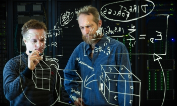 NREL scientists Michael Crowley and Antti-Pekka Hynninen have developed algorithms that speed calculations done by the software tool CHARMM by several orders of magnitude, using code such as the one pictured. Using NREL's new petascale supercomputer housed in the Energy Systems Integration Facility, they can simulate the motions of thousands of atoms, leading to greater understanding of how molecular models work. | Photo by Dennis Schroeder, NREL. NREL scientists Michael Crowley and Antti-Pekka Hynninen have developed algorithms that speed calculations done by the software tool CHARMM by several orders of magnitude, using code such as the one pictured. Using NREL's new petascale supercomputer housed in the Energy Systems Integration Facility, they can simulate the motions of thousands of atoms, leading to greater understanding of how molecular models work. | Photo by Dennis Schroeder, NREL.