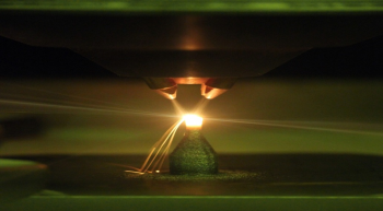 Green light reflection from a low-oxygen environment, 3D-printer laser deposition of metal powder alloys.
| Photo courtesy of Critical Materials Institute, Ames Laboratory
Green light reflection from a low-oxygen environment, 3D-printer laser deposition of metal powder alloys.
| Photo courtesy of Critical Materials Institute, Ames Laboratory