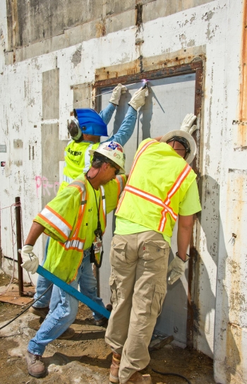 From left, Baker Concreteâs Charles Powell, Archie Jarrell, and Michael Carter weld shut the last opening to the P Reactor 105-P building. Baker performed the in situ grouting of the below-grade areas. From left, Baker Concreteâs Charles Powell, Archie Jarrell, and Michael Carter weld shut the last opening to the P Reactor 105-P building. Baker performed the in situ grouting of the below-grade areas.