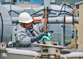 Andy Harris moves the VOC transfer hose from one tank to the next while wearing a supplied-air breathing apparatus. Andy Harris moves the VOC transfer hose from one tank to the next while wearing a supplied-air breathing apparatus.