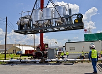 Employees lower a carbon treatment system into place to remove groundwater contamination from near an equipment cleaning building in the middle of the Paducah site. Employees lower a carbon treatment system into place to remove groundwater contamination from near an equipment cleaning building in the middle of the Paducah site.