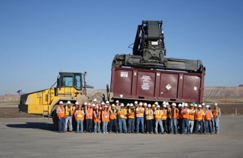 The day crew at the Crescent Junction Disposal site stands in front of the container carrying the 4 millionth ton of mill tailings from the Moab site. The day crew at the Crescent Junction Disposal site stands in front of the container carrying the 4 millionth ton of mill tailings from the Moab site.