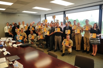 Participants of an energy education meeting at the U.S. Naval Academy hold up the Energy Literacy Framework. | Energy Department photo Participants of an energy education meeting at the U.S. Naval Academy hold up the Energy Literacy Framework. | Energy Department photo