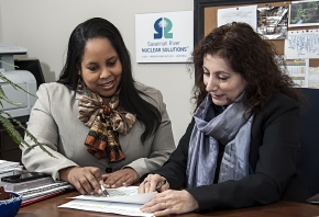 Sabrina Elam (left) and Lorri Wright, who work in procurement for SRNS, review the savings the company achieved. Sabrina Elam (left) and Lorri Wright, who work in procurement for SRNS, review the savings the company achieved.