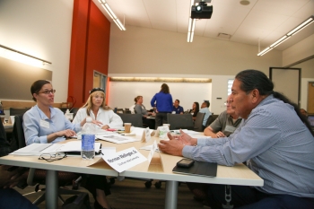 Workshop guest speaker Jana Ganion of Blue Lake Rancheria (shown here to the left sitting at a table with workshop participants) provided an inspiring story of how effective strategic energy planning can help a Tribe take a leadership role in renewable energy development. Photo by John De La Rosa, NREL Workshop guest speaker Jana Ganion of Blue Lake Rancheria (shown here to the left sitting at a table with workshop participants) provided an inspiring story of how effective strategic energy planning can help a Tribe take a leadership role in renewable energy development. Photo by John De La Rosa, NREL