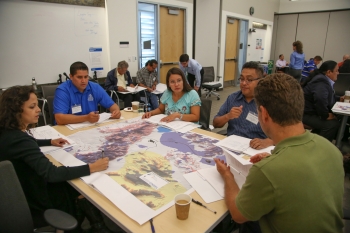 Workshop attendees reviewed renewable energy resource maps to identify the best sites for potential projects based on available resources. Photo by John De La Rosa, NREL Workshop attendees reviewed renewable energy resource maps to identify the best sites for potential projects based on available resources. Photo by John De La Rosa, NREL