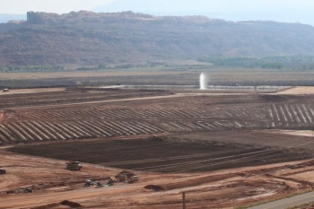 Pictured here is the Moab uranium mill tailings pile. Tailings excavation and conditioning activities are seen in the foreground. The water spray is used to eliminate extracted contaminated groundwater. Pictured here is the Moab uranium mill tailings pile. Tailings excavation and conditioning activities are seen in the foreground. The water spray is used to eliminate extracted contaminated groundwater.