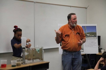 Jeff Wurtz, a Navarro-Intera hydrologist at the Nevada National Security Site, gets some help from GEAR UP summer camp student, Donnea Mayfield, to demonstrate the dynamics of the water cycle and how humans affect it. Jeff Wurtz, a Navarro-Intera hydrologist at the Nevada National Security Site, gets some help from GEAR UP summer camp student, Donnea Mayfield, to demonstrate the dynamics of the water cycle and how humans affect it.