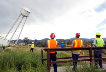 Workers observe the demolition of the West Water Tower at Los Alamos National Laboratory. Workers observe the demolition of the West Water Tower at Los Alamos National Laboratory.