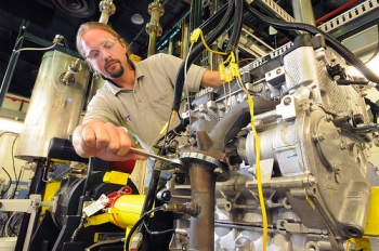 Argonne mechanical engineer Thomas Wallner adjusts Argonne's "omnivorous engine," an automobile
engine that Wallner and his colleagues have tailored to efficiently run on blends of gasoline, ethanol and
butanol. | Courtesy of: Argonne National Laboratory. Argonne mechanical engineer Thomas Wallner adjusts Argonne's "omnivorous engine," an automobile
engine that Wallner and his colleagues have tailored to efficiently run on blends of gasoline, ethanol and
butanol. | Courtesy of: Argonne National Laboratory.