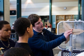 The <a href="http://www.windpoweringamerica.gov/windcompetition">Collegiate Wind Competition</a> is one of several Energy Department-supported programs aiming to inspire the next generation of clean energy leaders. Here, JMU student Greg Miller demonstrates how the blades of a wind turbine work as part the Wind for Schools project. | Photo courtesy of the Virginia Center for Wind Energy. The <a href="http://www.windpoweringamerica.gov/windcompetition">Collegiate Wind Competition</a> is one of several Energy Department-supported programs aiming to inspire the next generation of clean energy leaders. Here, JMU student Greg Miller demonstrates how the blades of a wind turbine work as part the Wind for Schools project. | Photo courtesy of the Virginia Center for Wind Energy.