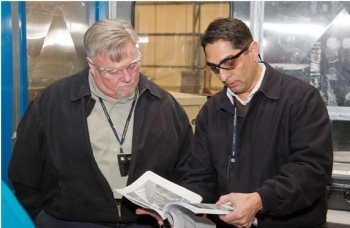 EM Deputy Assistant Secretary for Waste Management Frank Marcinowski, left, talks with LANLâs Oversized Container Disposition Project Manager Mike Romero while on a tour of the 375 box line facility in late February. EM Deputy Assistant Secretary for Waste Management Frank Marcinowski, left, talks with LANLâs Oversized Container Disposition Project Manager Mike Romero while on a tour of the 375 box line facility in late February.