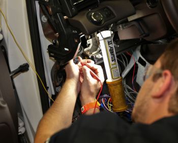 A team member from the Embry Riddle Aeronautical University team checks the main point of connection of the low voltage system. This connection allows communication with the charger, eventually ensuring the vehicleâs battery will stay charged. | Photo courtesy of EcoCAR 2. A team member from the Embry Riddle Aeronautical University team checks the main point of connection of the low voltage system. This connection allows communication with the charger, eventually ensuring the vehicleâs battery will stay charged. | Photo courtesy of EcoCAR 2.