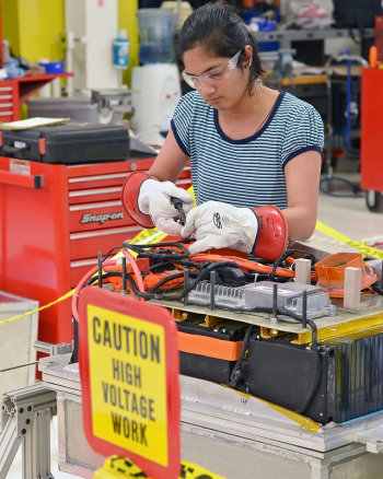 A team member from Purdue University works on a line for their vehicleâs high voltage battery. Purdue Universityâs vehicle is a split parallel hybrid. | Photo courtesy of EcoCAR 2. A team member from Purdue University works on a line for their vehicleâs high voltage battery. Purdue Universityâs vehicle is a split parallel hybrid. | Photo courtesy of EcoCAR 2.