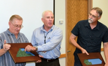 At Tuesday's Grand County Council meeting in Utah, Moab Federal Project Director Donald Metzler, center, moves a piece from a plaque representing Moabâs uranium mill tailings pile to a plaque representing the disposal cell in recognition of the site achieving a milestone by shipping 6 million tons of the tailings. Grand County Council Chair Gene Ciarus is on the left and Grand County Council Vice Chair Lynn Jackson is on the right. At Tuesday's Grand County Council meeting in Utah, Moab Federal Project Director Donald Metzler, center, moves a piece from a plaque representing Moabâs uranium mill tailings pile to a plaque representing the disposal cell in recognition of the site achieving a milestone by shipping 6 million tons of the tailings. Grand County Council Chair Gene Ciarus is on the left and Grand County Council Vice Chair Lynn Jackson is on the right.