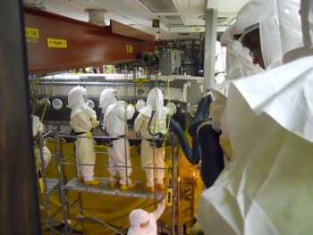 Workers wear air purifying respirators in the Plutonium Finishing Plant. Workers wear air purifying respirators in the Plutonium Finishing Plant.