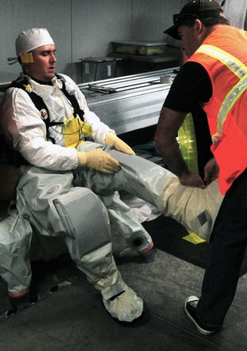 Members of the Hanford site team observe Advanced Mixed Waste Treatment Project workers at the Idaho site putting on protective equipment. The Level B protective suit is custom-designed to provide maximum flexibility and protection against potential workplace hazards. The containment suit, coupled with the breathing equipment shown in the photo below, enables work to be conducted safely in high-hazard atmospheres. Members of the Hanford site team observe Advanced Mixed Waste Treatment Project workers at the Idaho site putting on protective equipment. The Level B protective suit is custom-designed to provide maximum flexibility and protection against potential workplace hazards. The containment suit, coupled with the breathing equipment shown in the photo below, enables work to be conducted safely in high-hazard atmospheres.
