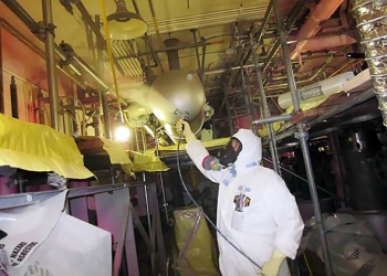 This photo is included in a report that discusses worker protective suits. The report is part of the lessons learned, best practices and other guidance now featured in the Deactivation and Decommissioning Knowledge Management Information Tool. The worker pictured, an insulator, is wearing a protective suit designed to fit better around the respirator and allow for improved breathing. This photo is included in a report that discusses worker protective suits. The report is part of the lessons learned, best practices and other guidance now featured in the Deactivation and Decommissioning Knowledge Management Information Tool. The worker pictured, an insulator, is wearing a protective suit designed to fit better around the respirator and allow for improved breathing.