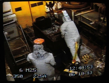 Members of the Hanford site team observe via remote video as Advanced Mixed Waste Treatment Project employees in protective gear work. Members of the Hanford site team observe via remote video as Advanced Mixed Waste Treatment Project employees in protective gear work.