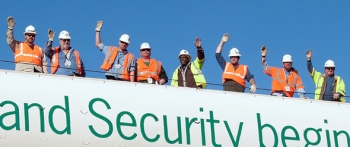Workers gather behind a âSafety and Security begins with Meâ banner at the Savannah River Site. Workers gather behind a âSafety and Security begins with Meâ banner at the Savannah River Site.