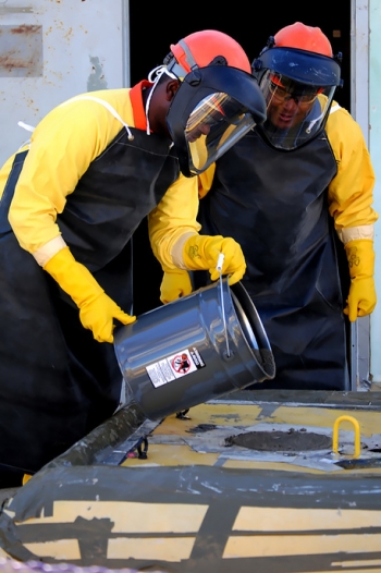 SRR employees Glenn Kelly and Fred Merriweather pour the final amount of grout into Tank 6. SRR employees Glenn Kelly and Fred Merriweather pour the final amount of grout into Tank 6.