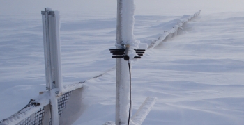 Monitoring equipment and part of the snowfence peek out of the snow drift. Monitoring equipment and part of the snowfence peek out of the snow drift.