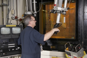 A Savannah River Remediation employee uses a manipulator located inside a shielded enclosure at the Defense Waste Processing Facility, where a melter pours molten glass into a canister. A Savannah River Remediation employee uses a manipulator located inside a shielded enclosure at the Defense Waste Processing Facility, where a melter pours molten glass into a canister.