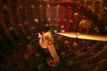 The interior of the National Ignition Facility target chamber at Lawrence Livermore National Laboratory. The service module carrying technicians can be seen on the left. The target positioner, which holds the target, is on the right. | Photo courtesy of Lawrence Livermore National Laboratory. The interior of the National Ignition Facility target chamber at Lawrence Livermore National Laboratory. The service module carrying technicians can be seen on the left. The target positioner, which holds the target, is on the right. | Photo courtesy of Lawrence Livermore National Laboratory.