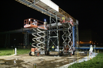 Second-shift Recovery Act workers at the Paducah Site use scissor lifts and metal saws to remove the outer cover of old uranium hexafluoride process tie lines linking C-410 with other parts of the Paducah Gaseous Diffusion Plant. Second-shift Recovery Act workers at the Paducah Site use scissor lifts and metal saws to remove the outer cover of old uranium hexafluoride process tie lines linking C-410 with other parts of the Paducah Gaseous Diffusion Plant.
