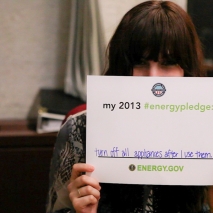 Download your own pledge card and submit a photo -- you might see yourself on energy.gov/pledge! Here, Amanda pledges to turn off all appliances when she's not using them to save energy. | Energy Department photo.