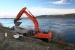 An excavator scoops out a section of river outfall pipeline at an F Area waste site. The pipeline was used to discharge effluent into the Columbia River.