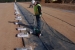 The liner installer heat-welds a sand anchor closed. The sand anchors are installed under the liner and across the length of the slit trench to keep the liner in place and minimize the effects of wind lift.