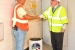 Marc Sharpe, who was a senior reactor operator at P Reactor in the mid-1980s, carries a time capsule containing items that reveal Site and national current events into P Reactor. Dr. David Moody, U.S. Department of Energy-Savannah River Operation Office Manager, is walking behind him.