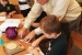 Mentor Jim Erickson of the LATA Kentucky team shows Heath Middle School sixthgrader Ian Morgan how to use red cabbage to indicate if a watery solution is acidic, basic, or neutral.