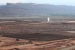 Pictured here is the Moab uranium mill tailings pile. Tailings excavation and conditioning activities are seen in the foreground. The water spray is used to eliminate extracted contaminated groundwater.