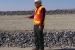 Moab Federal Project Director Donald Metzler stands on a final cover layer of the disposal cell. Several other layers are visible behind him.