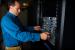 National Renewable Energy Laboratory (NREL) Technician Mic Stremel works with a blade server in the green data center at the Research Support Facility. 
| Image courtesy of NREL, Dennis Schroeder.