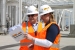 Pump-and-treat construction managers David Fink (left) and Delise Pargmann (right) review information for the LEED gold certification of the main process building for the 200 West Groundwater Treatment Facility.