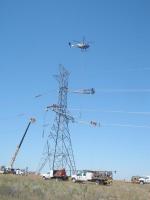 A helicopter hoists platforms for linemen during the construction of this single-circuit 500-kilovolt tower – one of hundreds on the McNary-John Day line saving BPA big bucks. | Photo courtesy of Bonneville Power Administration