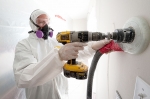 A weatherization worker drills holes to blow cellulose insulation in the interior walls of this home. | Photo courtesy of Dennis Schroeder, NREL