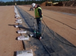 The liner installer heat-welds a sand anchor closed. The sand anchors are installed under the liner and across the length of the slit trench to keep the liner in place and minimize the effects of wind lift.