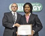 Shelton Clark, President of Eberline Services, receives the Small Business of the Year award from Dot Harris, Director of the Office of Economic Impact and Diversity. Eberline Services, a New Mexico-based small business, gets 90% of their business from the Energy Department. They specialize in radiological protection and environmental services. | Photo by Charles Watkins, DOE Photographer.