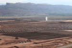 Pictured here is the Moab uranium mill tailings pile. Tailings excavation and conditioning activities are seen in the foreground. The water spray is used to eliminate extracted contaminated groundwater.