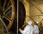 WIPP surface maintenance employees tail a new steel head rope over the hoist drum. The hoist is used to transport TRU waste 2,150 underground for final disposal.