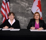Alice Williams of EM, left, and Joan Miller of the Atomic Energy of Canada Limited, sign a Statement of Intent (SOI).
